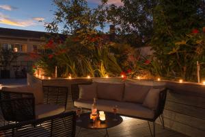 een patio met een bank en een tafel met verlichting bij L'Imprimerie Hôtel in Clichy