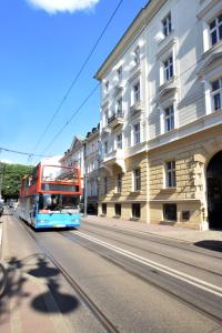 Dwupoziomowy autobus jadący ulicą miejską w obiekcie Piłsudskiego In City Apartments w Krakowie