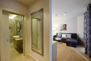 salon z kanapą i lustrem w obiekcie Piłsudskiego In City Apartments w Krakowie
