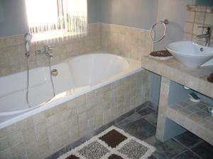 ein Badezimmer mit einer Badewanne und einem Waschbecken in der Unterkunft A la Bouge'Hôtes in Bellentre