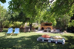 een tuin met 2 stoelen en een open haard bij Villa Karidia in Asprogerakata