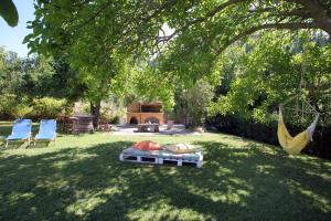 een achtertuin met twee stoelen en een hangmat in het gras bij Villa Karidia in Asprogerakata