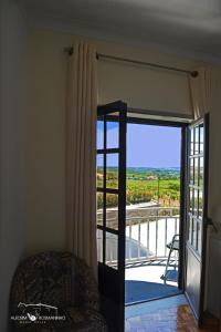 a room with a sliding glass door with a balcony at Alecrim Rosmaninho Guest House in Pinhel