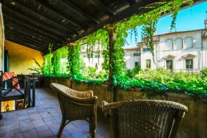 a patio with two chairs and a wall with vines at Villa Betteloni Valpolicella Suites in San Pietro in Cariano