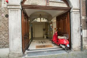 a red motorcycle parked in front of a building at Hotel Botticelli in Maastricht
