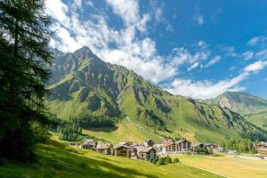 a village on a hill with a mountain in the background at Piz Ot in Samnaun