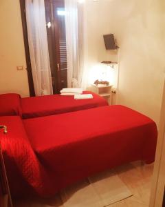 ein rotes Bett in einem kleinen Zimmer mit einer roten Decke in der Unterkunft B&B 500 Miglia  in Tempio Pausania