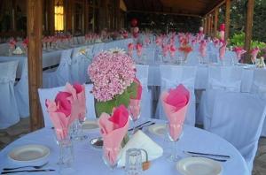 a table with pink flowers in vases on it at Hotel Kapsalis in Veria