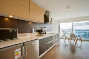 a kitchen with stainless steel appliances and a large window at Lima Walking Apartments - Central Miraflores in Lima