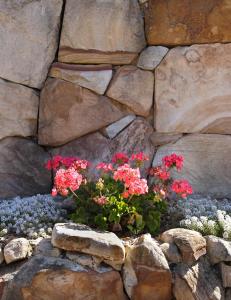 a stone wall with a bunch of flowers in it at Milton Village Motel in Milton