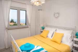 a bedroom with a yellow bed with yellow pillows at Apartments Sarbunal in Bol
