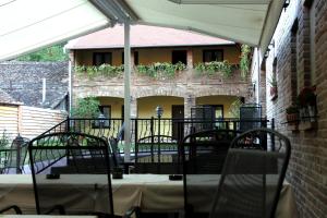 a patio with a table and chairs and a building at Rooms Villa Iva in Ilok