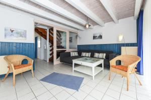 a living room with a couch and chairs and a table at Ferienhaus Strandperle in Bensersiel