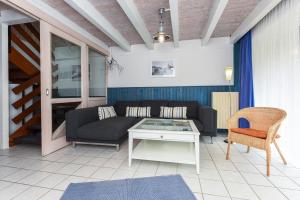 a living room with a couch and a table at Ferienhaus Strandperle in Bensersiel