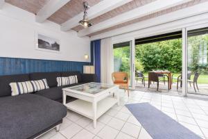 a living room with a couch and a table at Ferienhaus Strandperle in Bensersiel