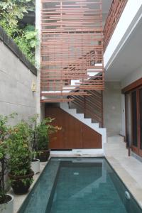 a house with a swimming pool and a staircase at Green Studio Apartment Seminyak in Seminyak