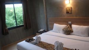 um quarto de hotel com duas camas e uma janela em Narai Iyara Palace em Ban Sa Maklua