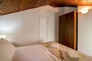 um quarto com uma cama e um armário de madeira em Apartmani Stefanovic em Herceg Novi