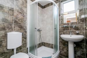 uma casa de banho com um chuveiro, um WC e um lavatório. em Apartmani Stefanovic em Herceg Novi