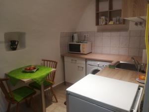 a kitchen with a table with a bowl of fruit on it at Apartman Bécsi utca in Sopron +6 photos