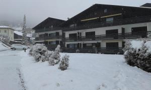 a snow covered yard in front of a building at Apartmenthaus Panorama in Seefeld in Tirol