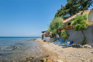 a group of blue chairs sitting on a beach at Sunrise Studio in Skala Kallirachis