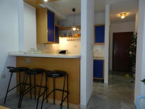 una cocina con armarios azules y taburetes en un mostrador en Nevada Apartaments, en Cenes de la Vega