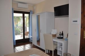 une pièce avec un bureau et une table avec un ordinateur dans l'établissement Il Palombaro, à Tropea