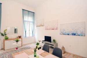 a white living room with a table and chairs at Lillybeth City Center Apartments in Budapest