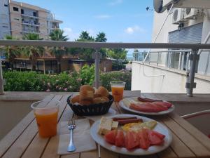 two plates of food on a wooden table with drinks at Duplex in Durrës