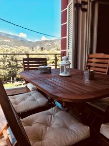 a wooden table on a balcony with a view of the mountains at Villa Lydia in Nydri