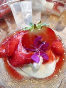 a dessert with a strawberry on a glass plate at Majatalo & Ravintola Villa Emilia in Ypäjä