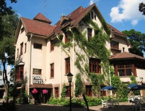 Un grand bâtiment blanc recouvert de lierre dans l'établissement Park Hotel Turku, à Turku