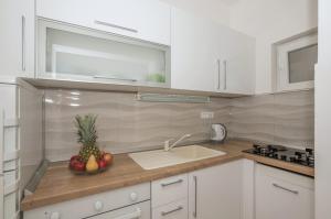a kitchen with a bowl of fruit on a counter at Apartman Pinto in Makarska