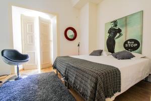Evora Inn في ايفورا: غرفة نوم مع سرير مع علامة كبيرة على الحائط