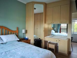 una camera da letto con un letto e una scrivania con uno specchio di Lemon Tree Cottage a Edgemead