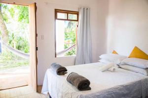 Un dormitorio con una cama con dos toallas encima. en Mangue Seco Lodge - Experiência Gastronômica, en Mangue Seco 169 fotos más