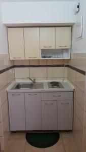 a kitchen with white cabinets and a sink at apartmani Vesna in Pinezici