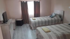 ein Hotelzimmer mit 2 Betten und einem TV in der Unterkunft Casa AnaMaria in Turda