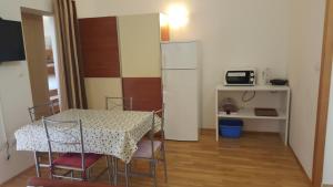 a small kitchen with a table and a refrigerator at apartmani Vesna in Pinezici