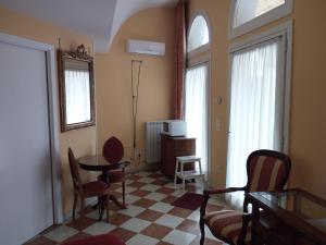 uma sala de estar com uma mesa, cadeiras e janelas em Villa Olanda em Mira