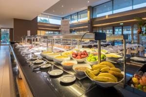 a buffet line with bowls of fruit and other foods at NAU Sao Rafael Atlantico in Albufeira