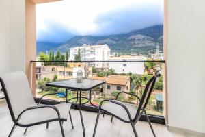 een tafel en stoelen op een balkon met uitzicht bij Villa Casa Mia in Sutomore