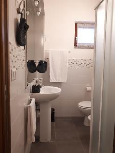 bagno bianco con lavandino e servizi igienici di Le Ortensie ad Arezzo