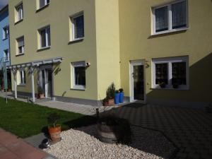 a yellow building with potted plants in front of it at Ferienwohnung Latscha in Kappel-Grafenhausen
