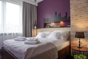 a bedroom with a large white bed with towels on it at AGA Tenis Apartments by Radwańska in Krakow