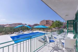 balcone con piscina, tavolo e sedie di Neda House a Vodice