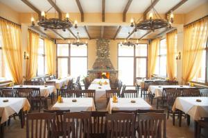a restaurant with tables and chairs and a fireplace at Hotel Kapsalis in Veria