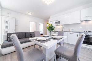 una cucina e un soggiorno con tavolo e sedie bianchi di Neda House a Vodice