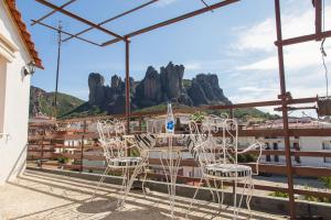 a table and chairs on a balcony with mountains at Tasos House in Kalabaka
